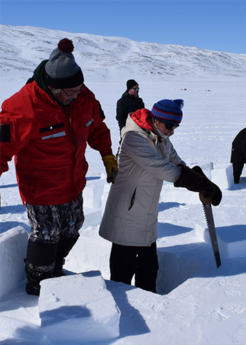 People sawing ice blocks for igloos